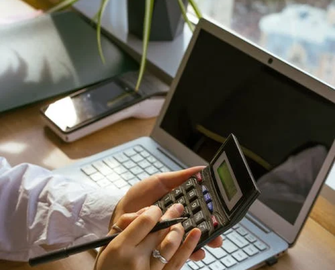 Calculator and laptop on a desk
